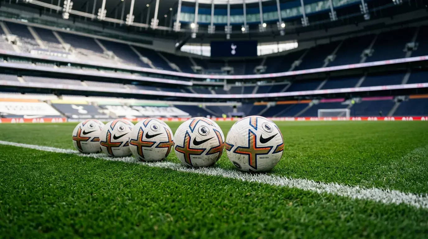 Varios balones de fútbol de la Premier League alineados sobre el césped de un estadio inglés